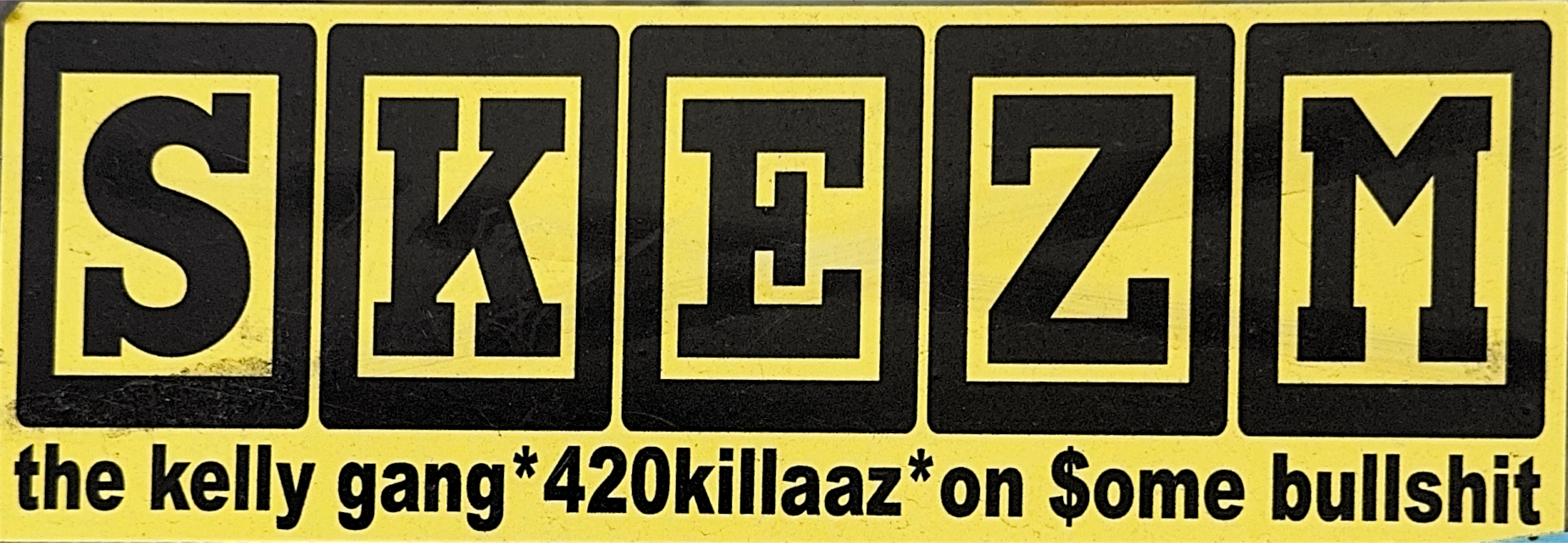 A yellow sticker in five black panels spelling SKETM in varsity lettering, captioned the kelly gang * 420killaaz * on $ome bullshit.